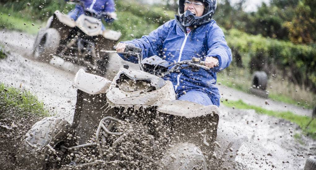 Hen making a splash through the mud on quad bike